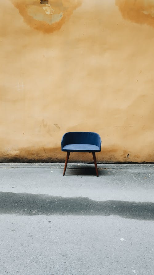 棕色墙旁边的蓝色和黑色椅子 · 免费素材图片