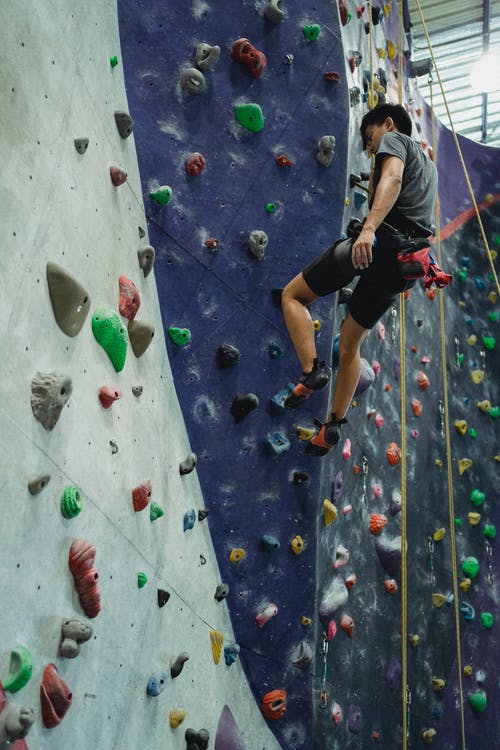 男登山者挂在锚索上 · 免费素材图片