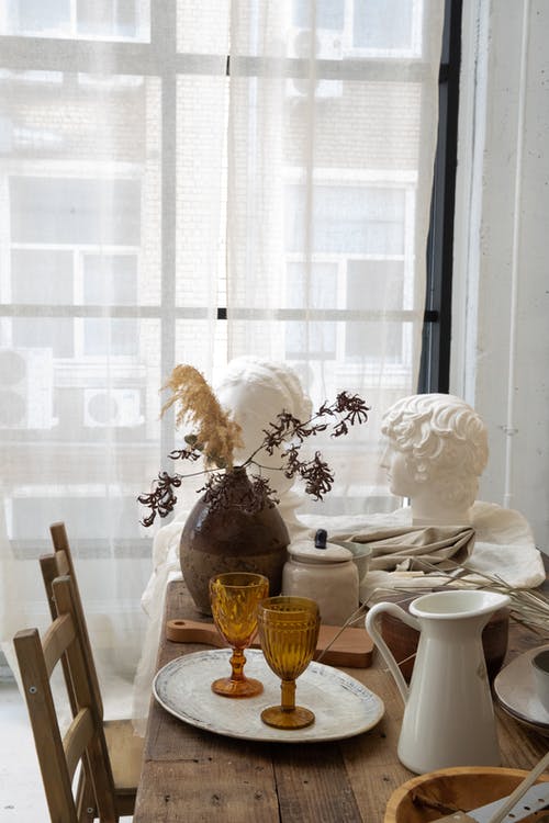 桌子与石半身像和装饰玻璃器皿在车间 · 免费素材图片