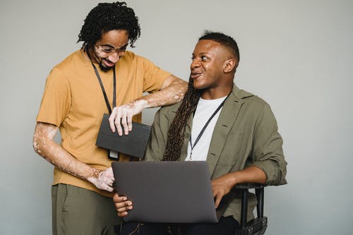 乐观的黑人同事与笔记本电脑 · 免费素材图片
