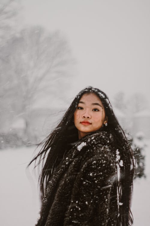 黑色连帽衫站在雪地上的女人 · 免费素材图片