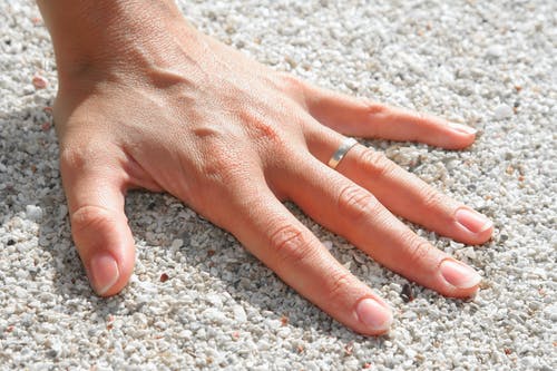 左手人类的手在土壤上戴银戒指 · 免费素材图片