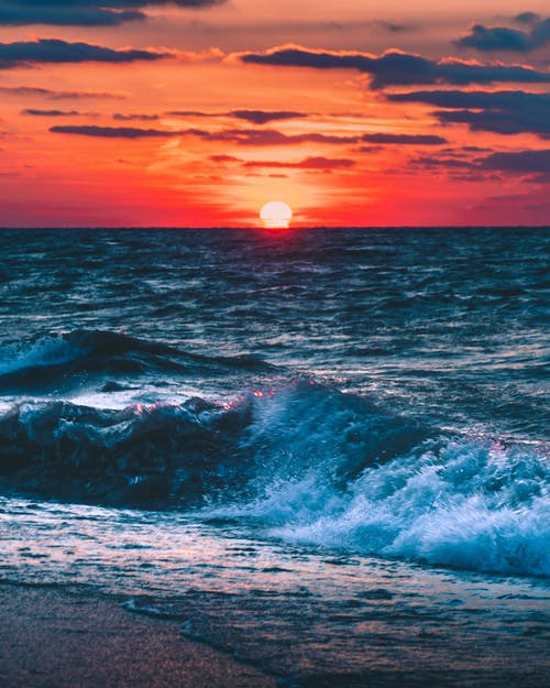 日落期间海洋的照片 · 免费素材图片