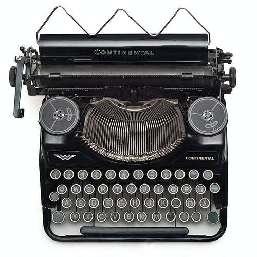 白色表面上的黑色大陆打字机 · 免费素材图片