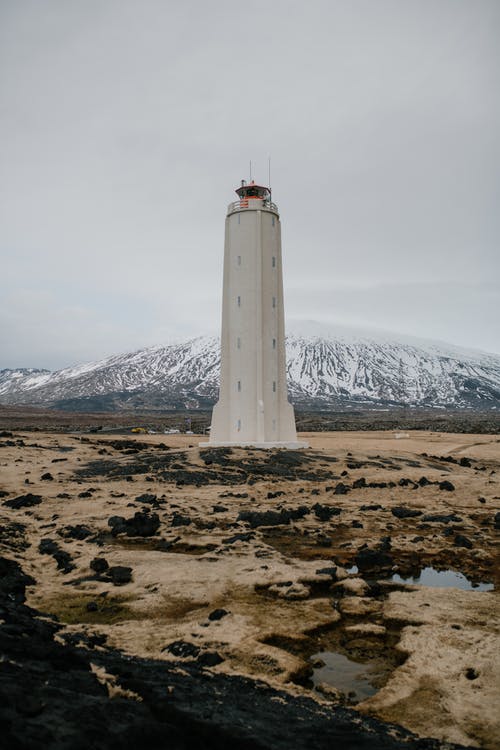 白色的灯塔，在棕色的沙子，在白色的天空下 · 免费素材图片