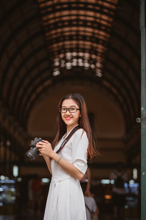 拿着照相机的妇女 · 免费素材图片