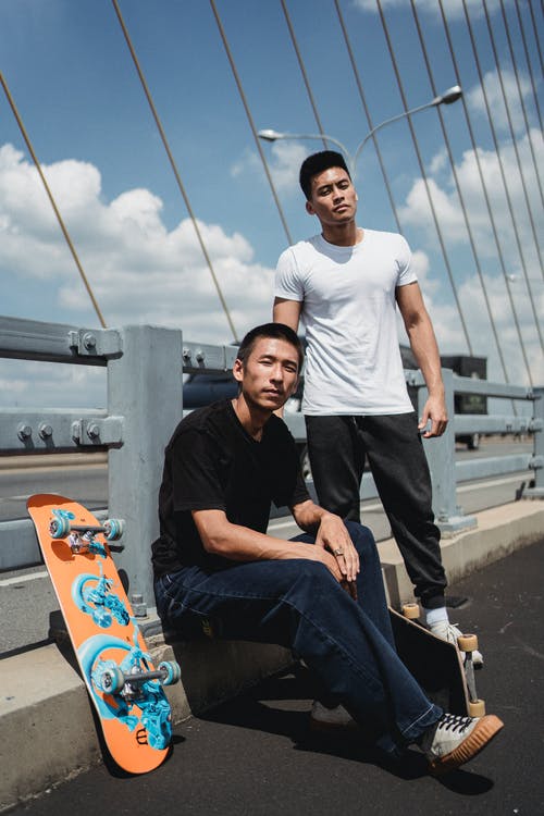 亚洲男子与城市桥梁上的滑板 · 免费素材图片