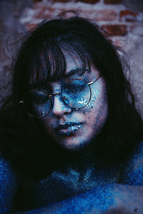 女人戴着眼镜覆盖着蓝色的灰尘 · 免费素材图片