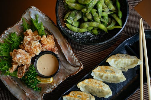 黑豆和油炸食品旁的黑色板上的饺子 · 免费素材图片