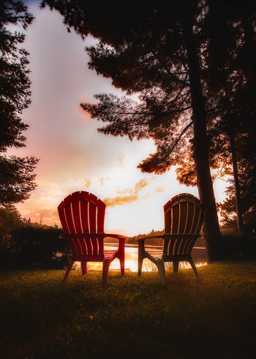 日落时对树木的桌子上的椅子 · 免费素材图片