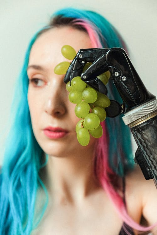女人抱着一串绿色的葡萄 · 免费素材图片