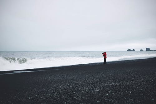 红顶站在水体附近的人 · 免费素材图片