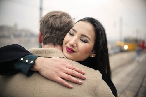 黑色外套的女人抱着棕色外套的男人 · 免费素材图片