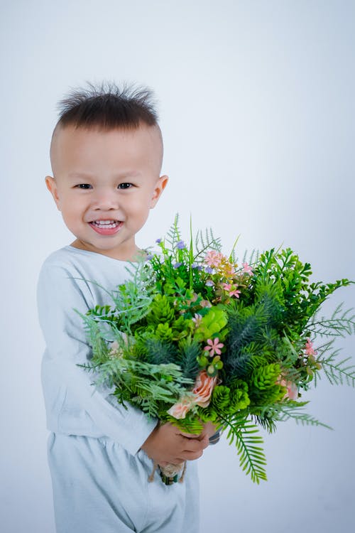 婴儿抱着蕨叶 · 免费素材图片