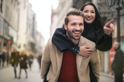 棕色外套的男人微笑着在黑色外套的女人旁边 · 免费素材图片