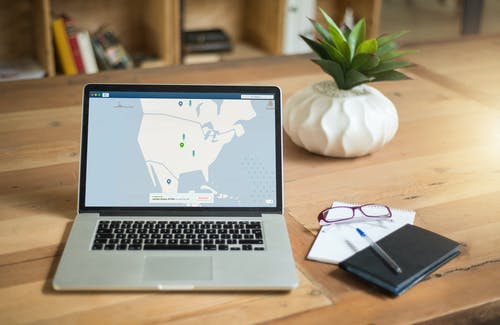 Macbook Pro棕色木制的桌子上 · 免费素材图片