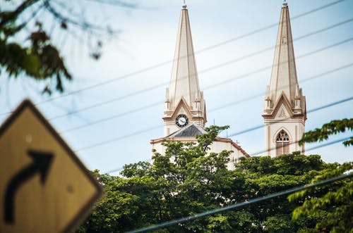 道路标志箭头和白色的混凝土塔和绿树 · 免费素材图片