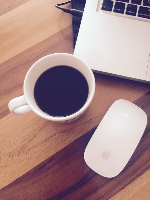 一杯黑咖啡旁边的苹果魔术鼠标 · 免费素材图片
