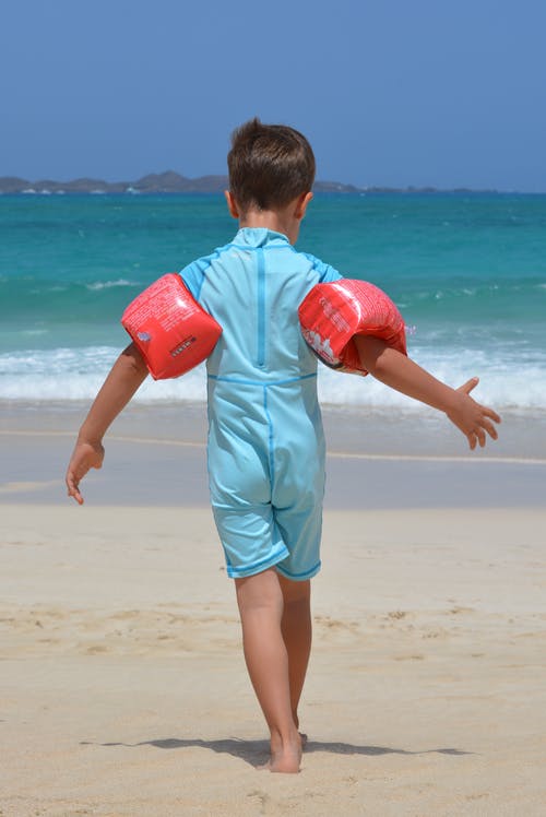 白天在海滩上的蓝onesie的男孩 · 免费素材图片