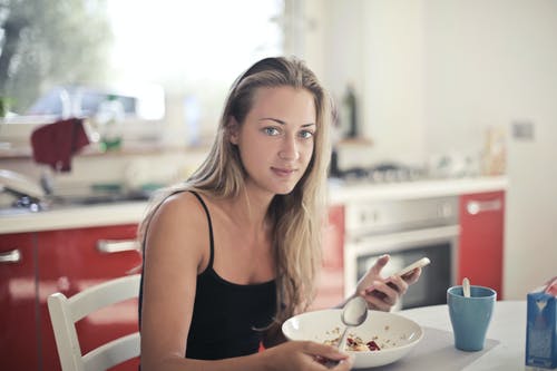黑色背心吃燕麦片的女人 · 免费素材图片