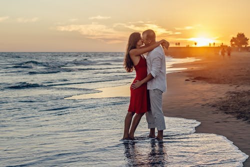 黄金时段情侣在海滩上接吻 · 免费素材图片