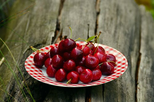 白色和红色陶瓷圆板上的樱桃果 · 免费素材图片