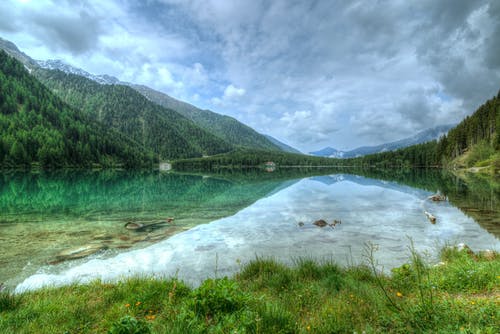 树木覆盖的山附近的湖 · 免费素材图片