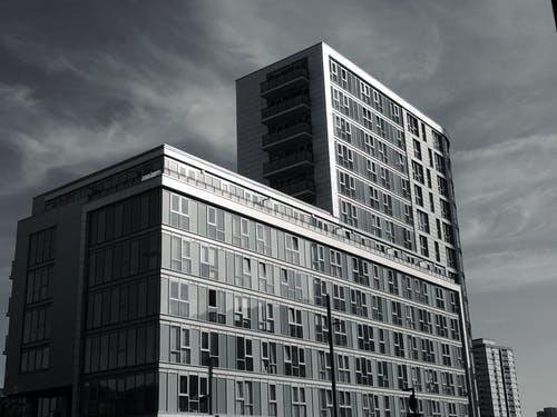 多云的天空下建筑物的灰度照片 · 免费素材图片