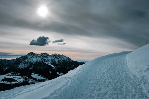 多云的天空下的积雪的山 · 免费素材图片