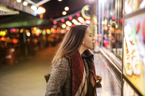 棕色外套在夜间站在人行道上的女人 · 免费素材图片