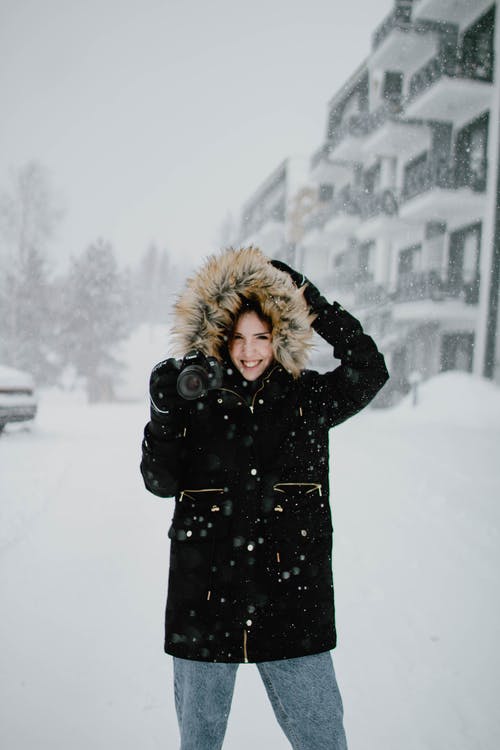 黑色外套站在雪地上的女人 · 免费素材图片