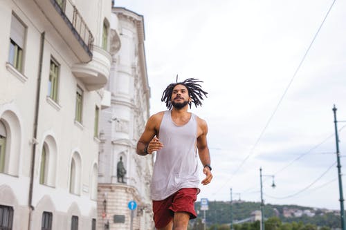 白色背心和栗色短裤在街上奔跑的人 · 免费素材图片