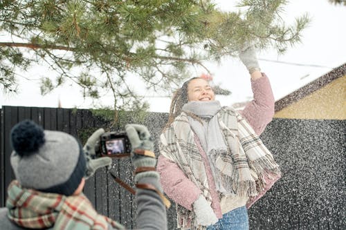 粉红色的外套和雪一起玩的女人 · 免费素材图片