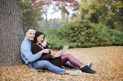 夫妻坐在树干附近 · 免费素材图片