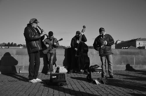 人们弹奏乐器的灰度照片 · 免费素材图片