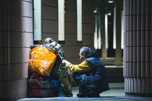 坐在捆绑袋前的男人 · 免费素材图片