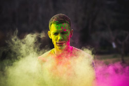 男子涂上绿色和紫色的油漆照片 · 免费素材图片