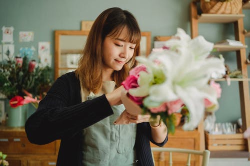 拿着花束的愉快的亚裔妇女 · 免费素材图片