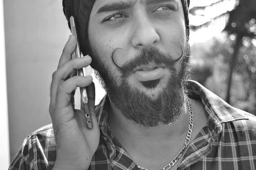 男子手持电话的灰度肖像照片 · 免费素材图片