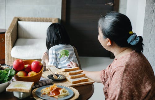 与吃午饭的孙女的匿名女人 · 免费素材图片