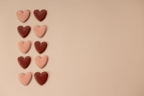 白色表面上的粉红色心形糖果 · 免费素材图片