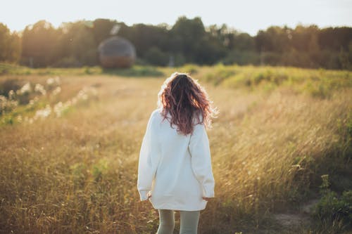 女人站在球场上穿白夹克时站着 · 免费素材图片