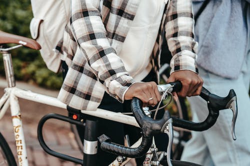 骑自行车的白色黑色和灰色格子长袖衬衫的人 · 免费素材图片