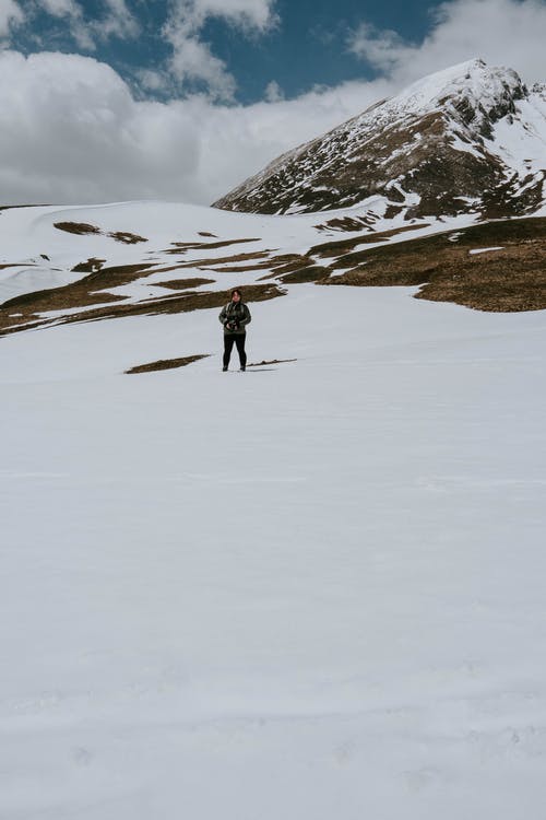 站在白雪皑皑的山上的人 · 免费素材图片