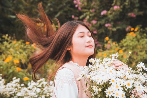 女人背着雏菊花束 · 免费素材图片