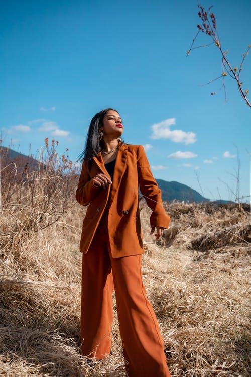 站在棕色的草地上的棕色外套的女人 · 免费素材图片