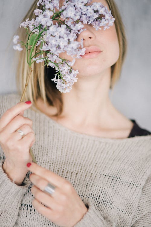 拿着白花花束的白色针织毛衫的女人 · 免费素材图片