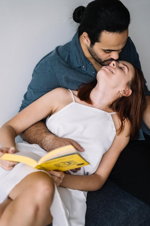 穿着蓝色衬衫的男人亲吻女人在白色意大利面条皮带顶部 · 免费素材图片