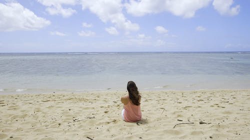 坐在海滩上的女孩 · 免费素材视频