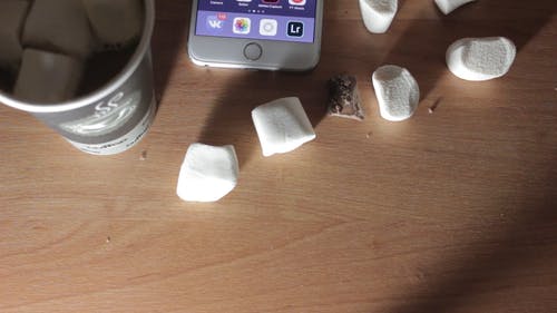 智能手机在桌子上用巧克力和棉花糖 · 免费素材视频